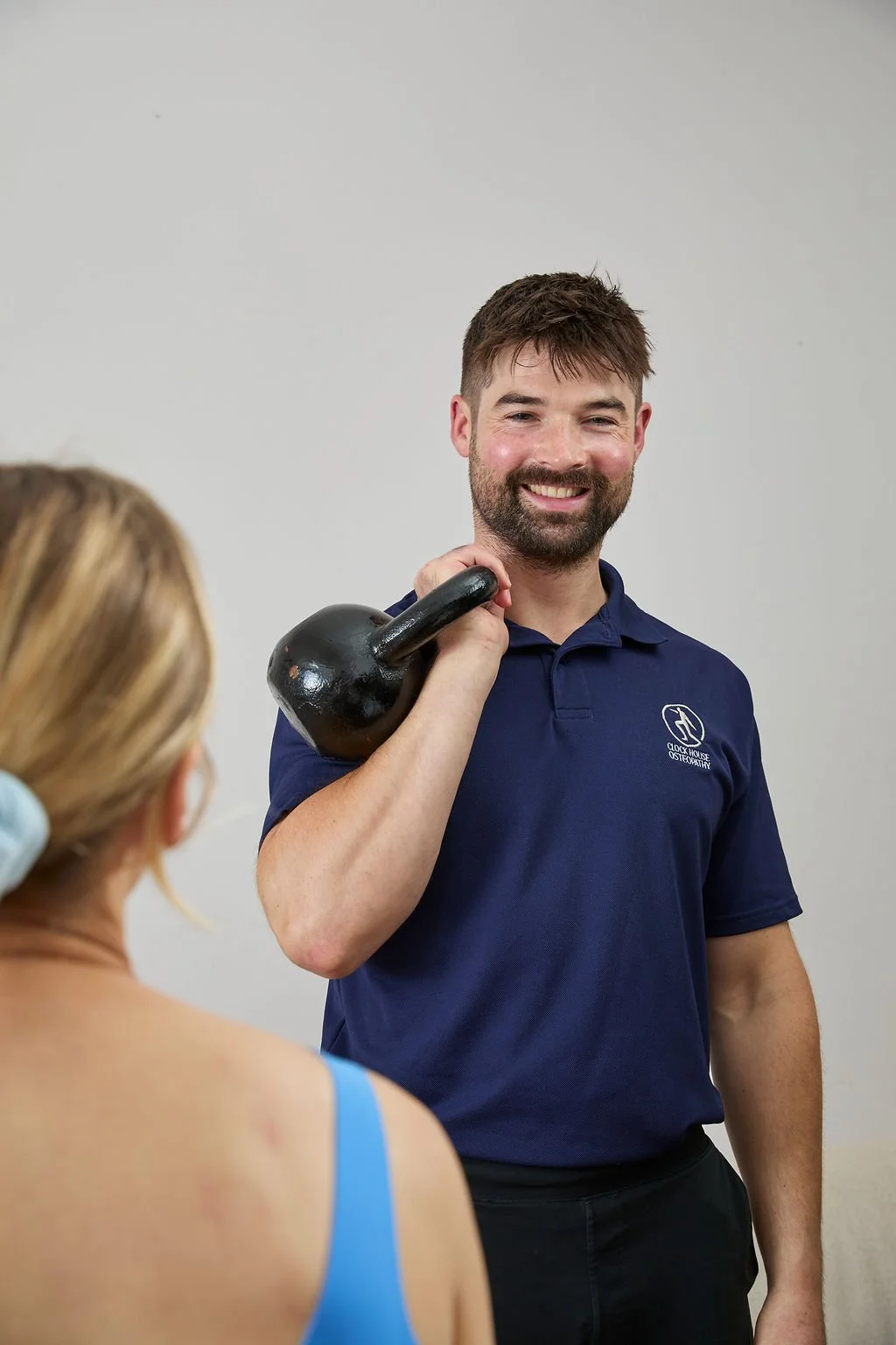 an osteopath in beckenham during a home visit doing a rehab exercise demonstration
