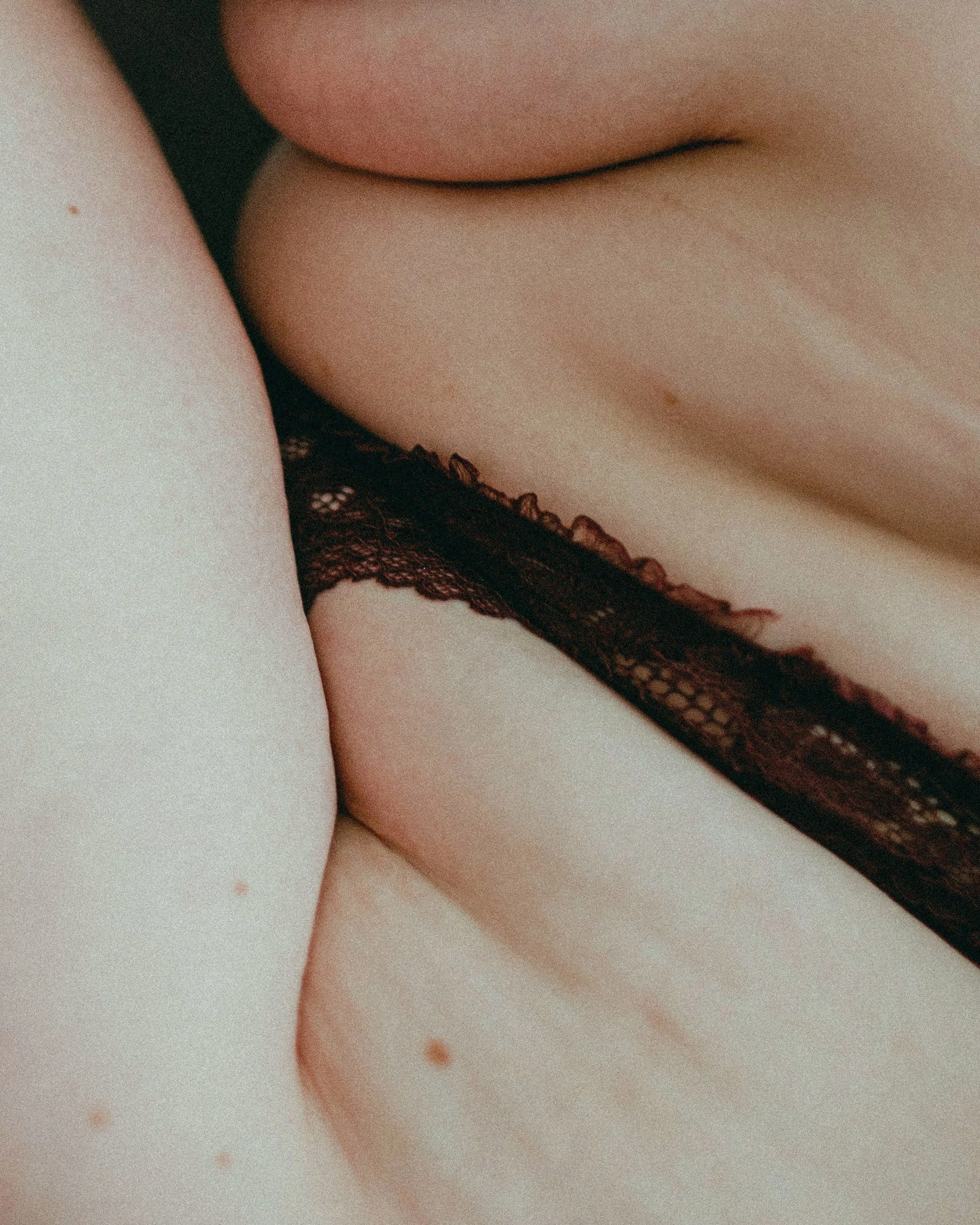 Close-up of a person's body wearing black lace lingerie.