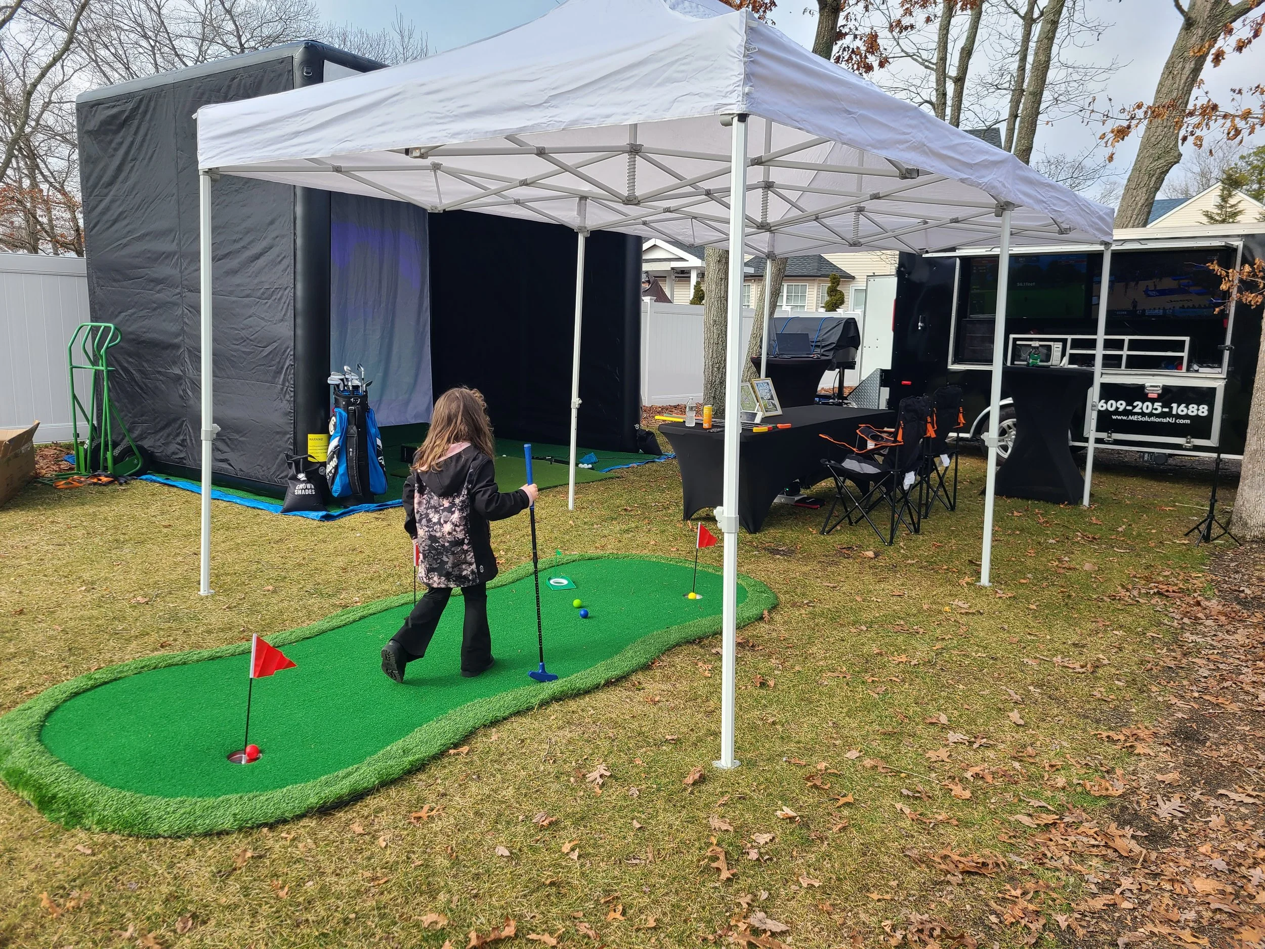Our mobile golf simulator with our tailgating/event/party trailer and putting green for the kids with tents, tables, and chairs.