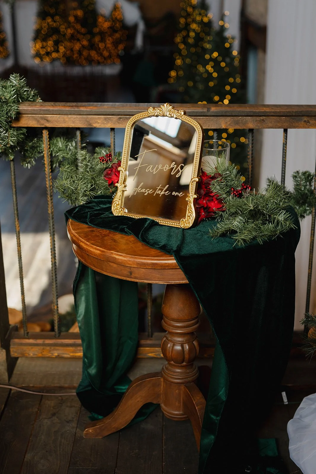 Gold filigree mirror wedding sign displayed on a styled table with greenery, fabric runner, and holiday-inspired décor