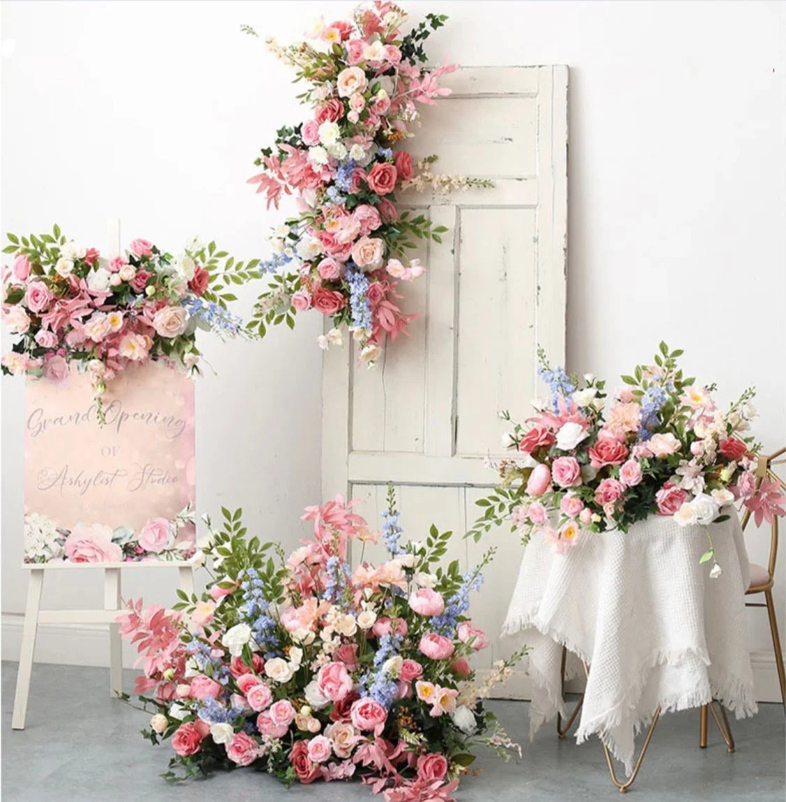 Romantic silk floral installation with blush, pink, and ivory blooms styled around a vintage door backdrop for a wedding or event display