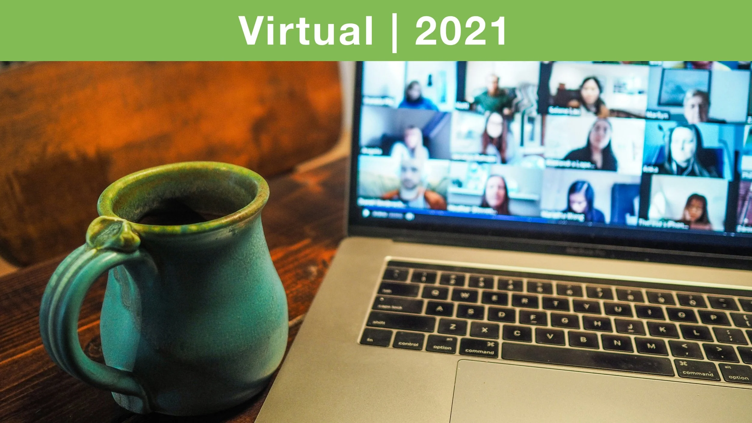 open laptop on a desk beside green coffee mug 2021