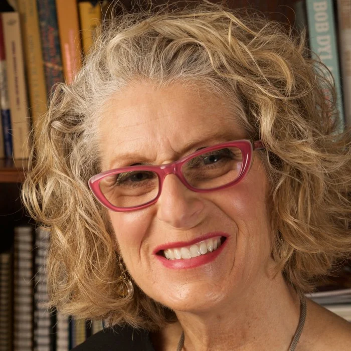 woman with wavy blond hair and glasses
