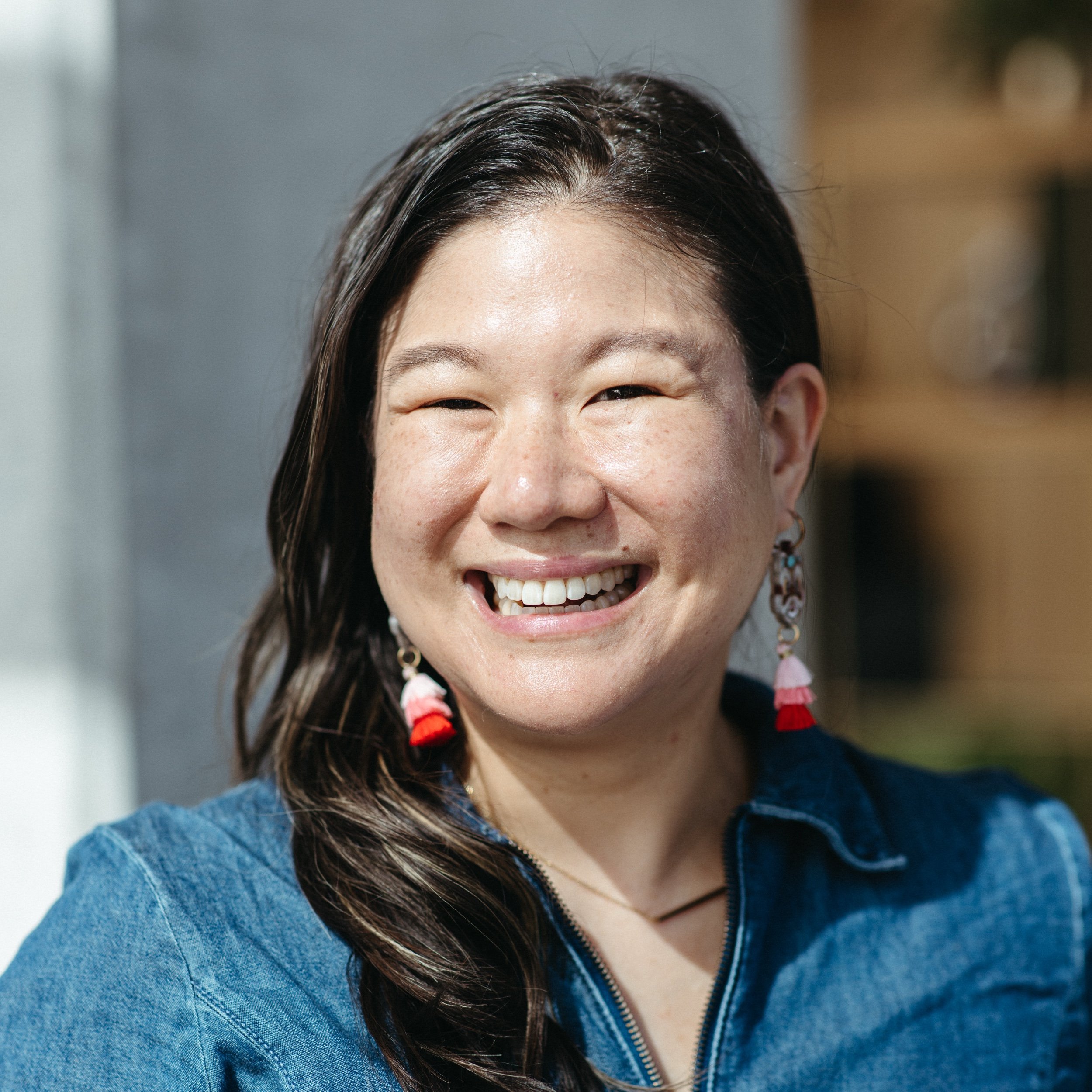 woman with long dark hair and dangle earrings