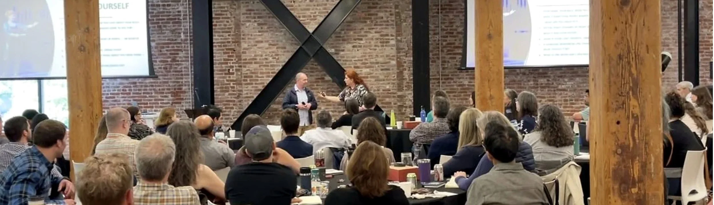 Demet Tuncer leading a workshop with a full audience at tables