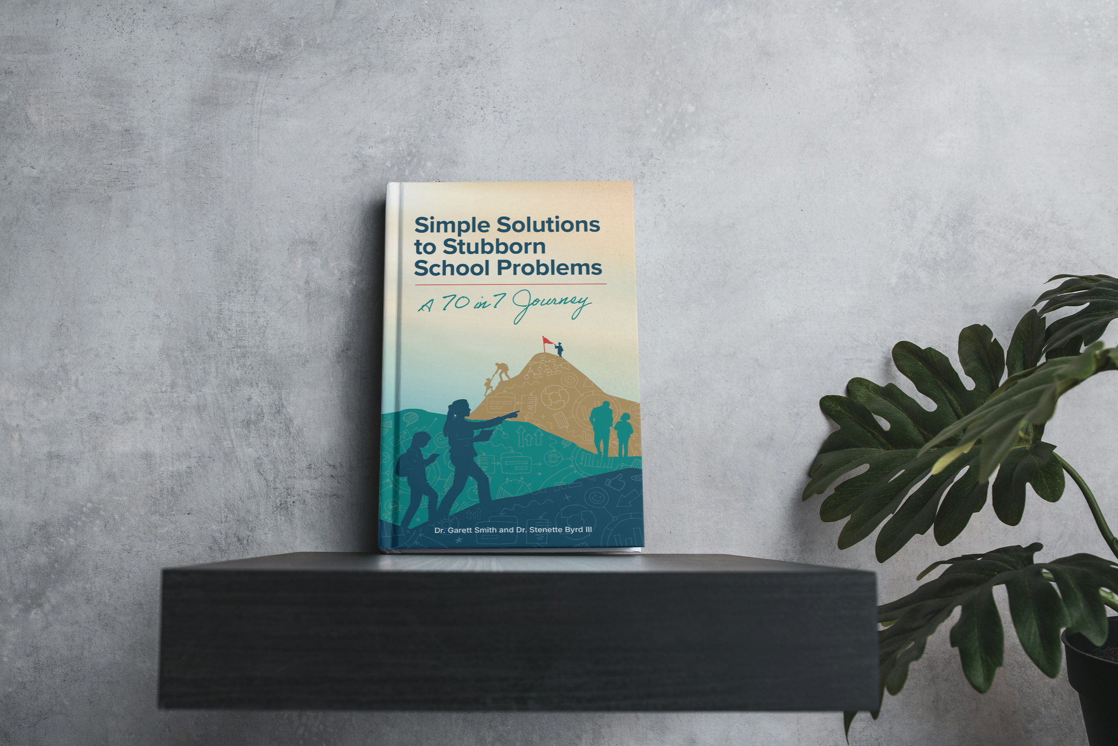 A book titled 'Simple Solutions to Stubborn School Problems: A 70 in 7 Journey' by Dr. Garett Smith and Dr. Stenette Byrd III is placed on a black shelf against a gray wall, with a large green potted plant nearby.