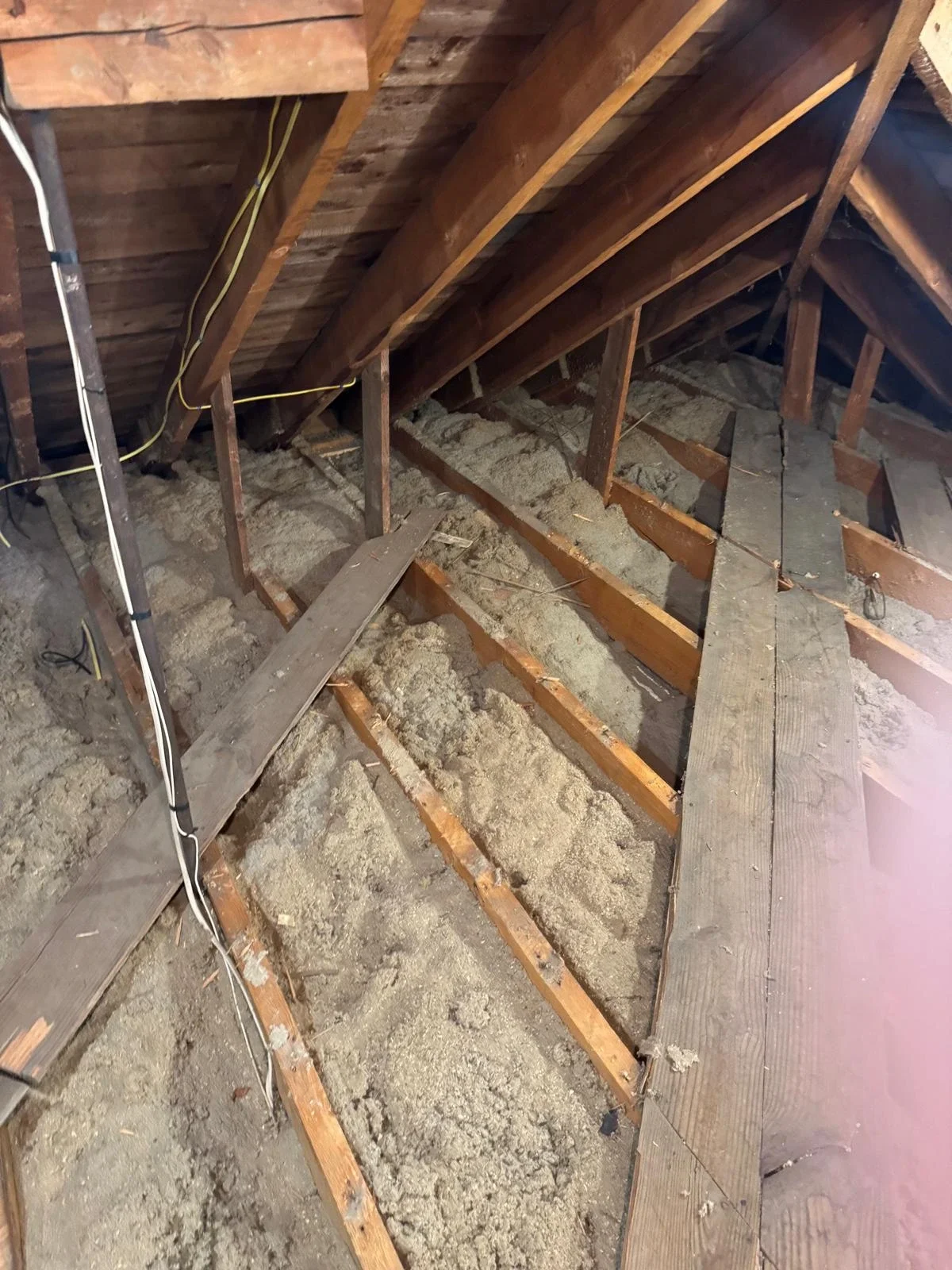 Old attic insulation and debris before professional removal
