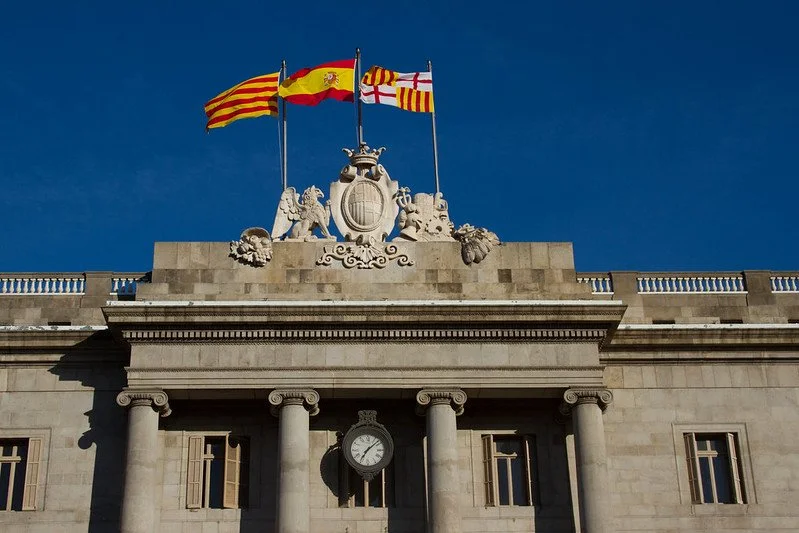 Yellow tray with a red heart face illustration with sunglasses and gold earrings shaped like cats, on a wooden surface.