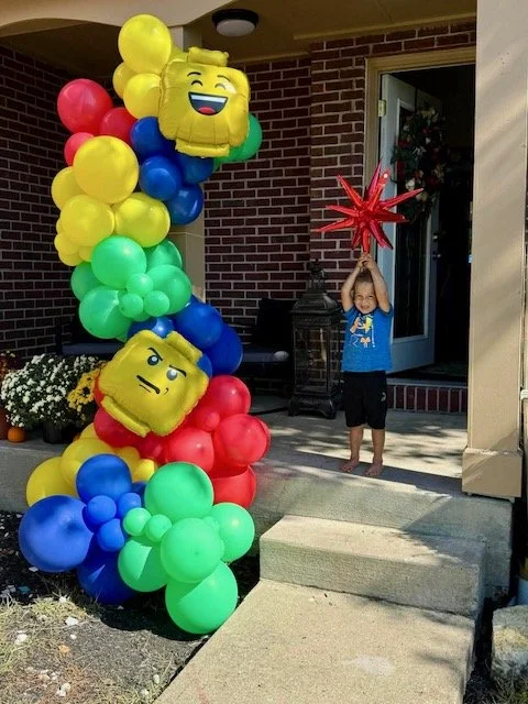 lego balloon garland with small child excited