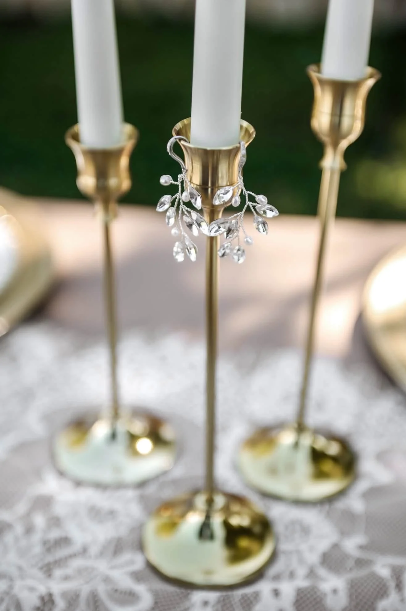 candle sticks at a wedding with brides earrings on them