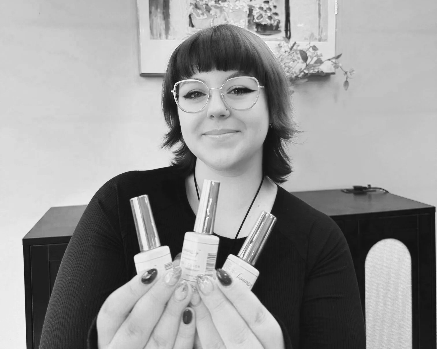 woman with glasses holding nail polish ashka salon