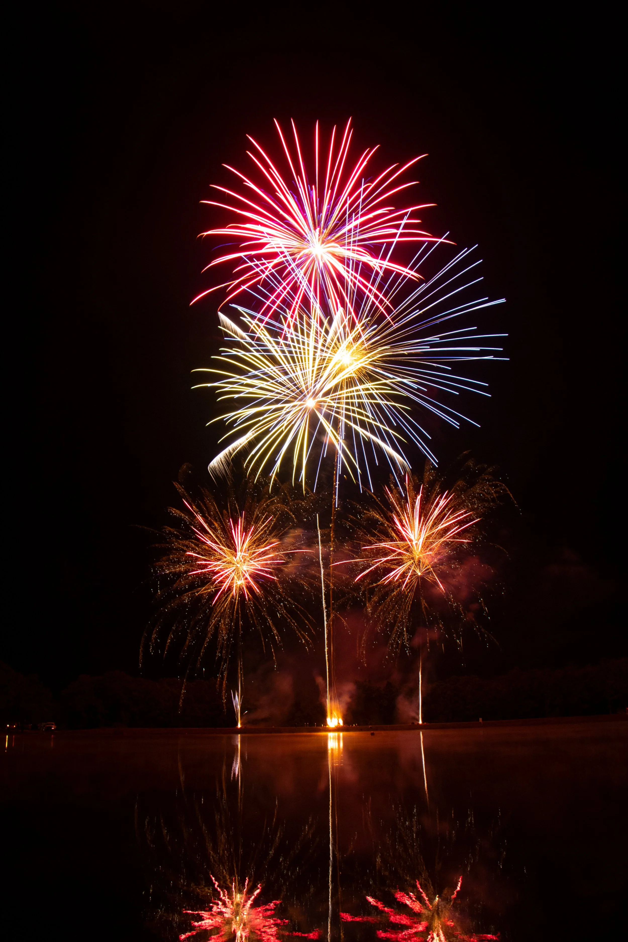 Red, White, & Blue combination of 1.3 and 1.4 fireworks in a pyromusical on a lake.