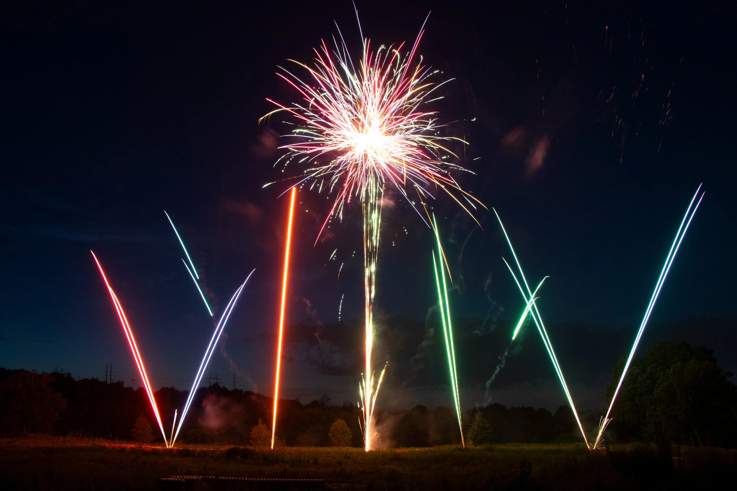 Colorful comets paired with aerial shells in a pyromusical fireworks display