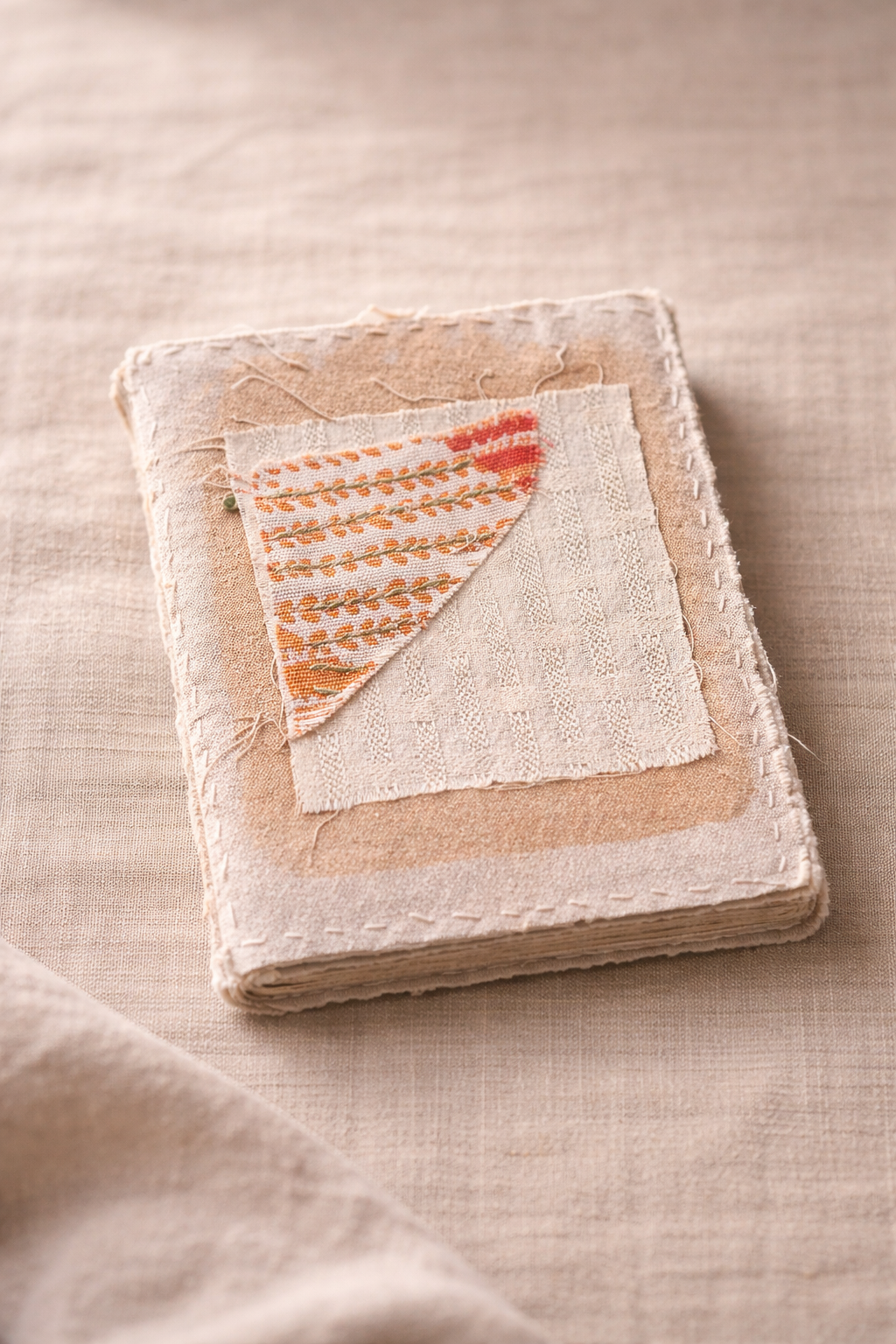 a handmade art journal made a stitched fabric front cover
