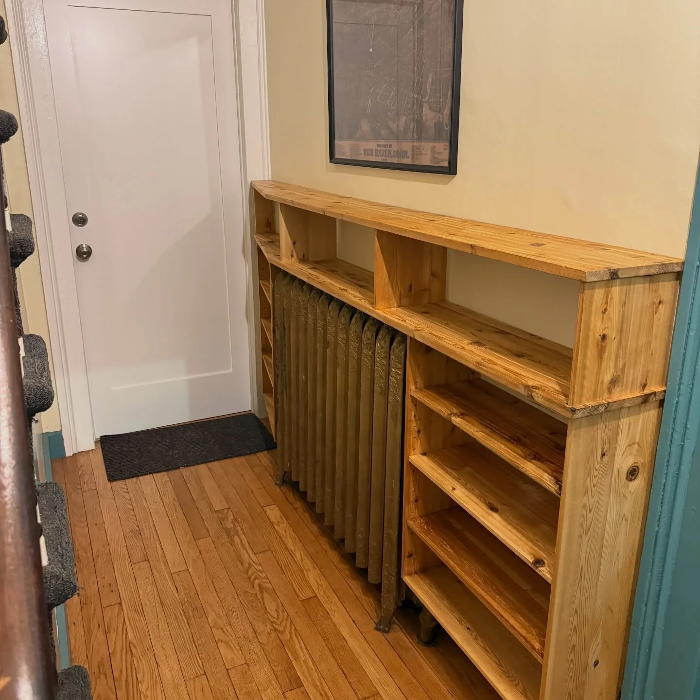 Is it a radiator cover? Kind of. 
Is it a shoe rack? Yes, and the shelves are adjustable.
Is it space-efficient? Extremely.

This solved the issue of useless front hallway space, which is common in old houses chopped up for apartments.
Lots of square