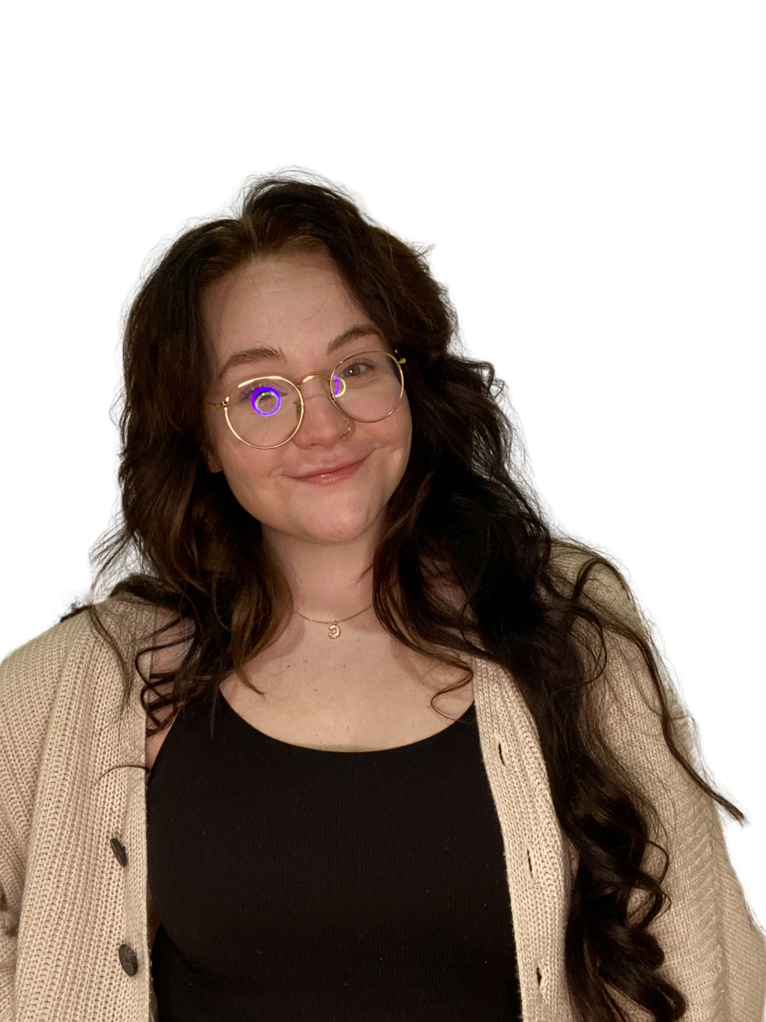 A young woman with long, dark, curly hair and glasses, smiling and looking at the camera, wearing a black top and a beige cardigan.