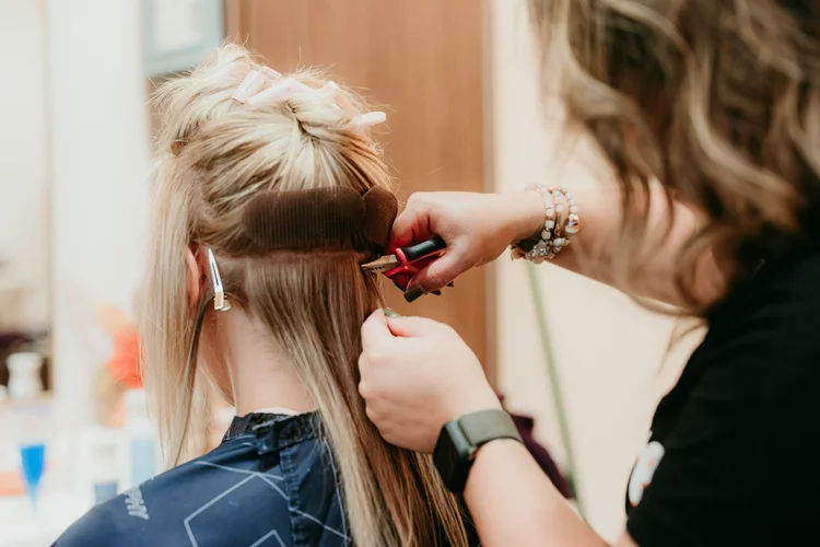 A stylist working with rollers and clips at The Purple Chair