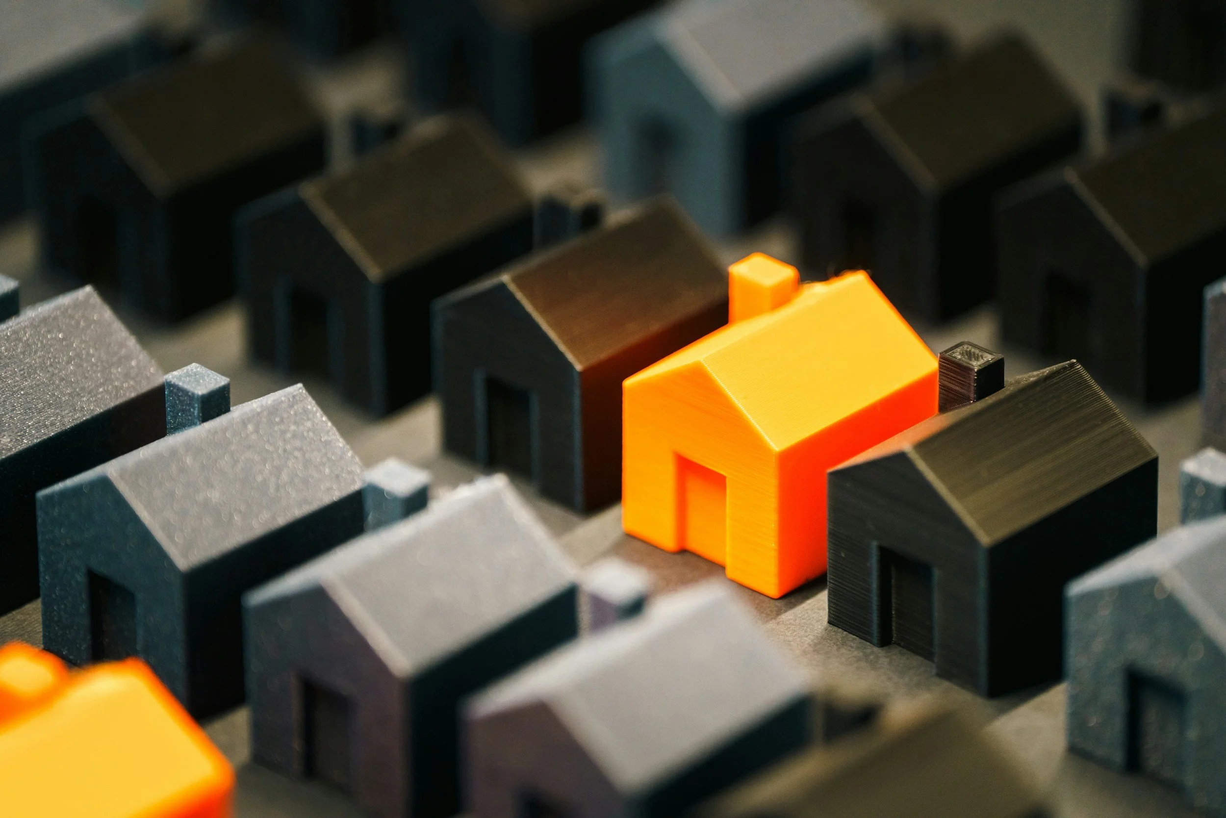 Visual of multiple rental properties with one dwelling highlighted in orange, symbolizing tracking income and expenses for an individual property in bookkeeping