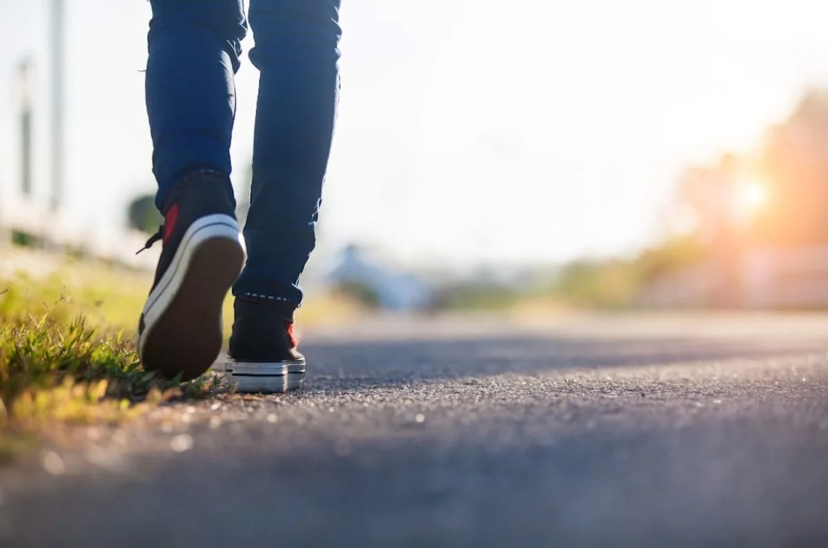 Feeling stuck in life, person walking alone on a quiet road at sunrise, symbolizing moving forward but still feeling behind