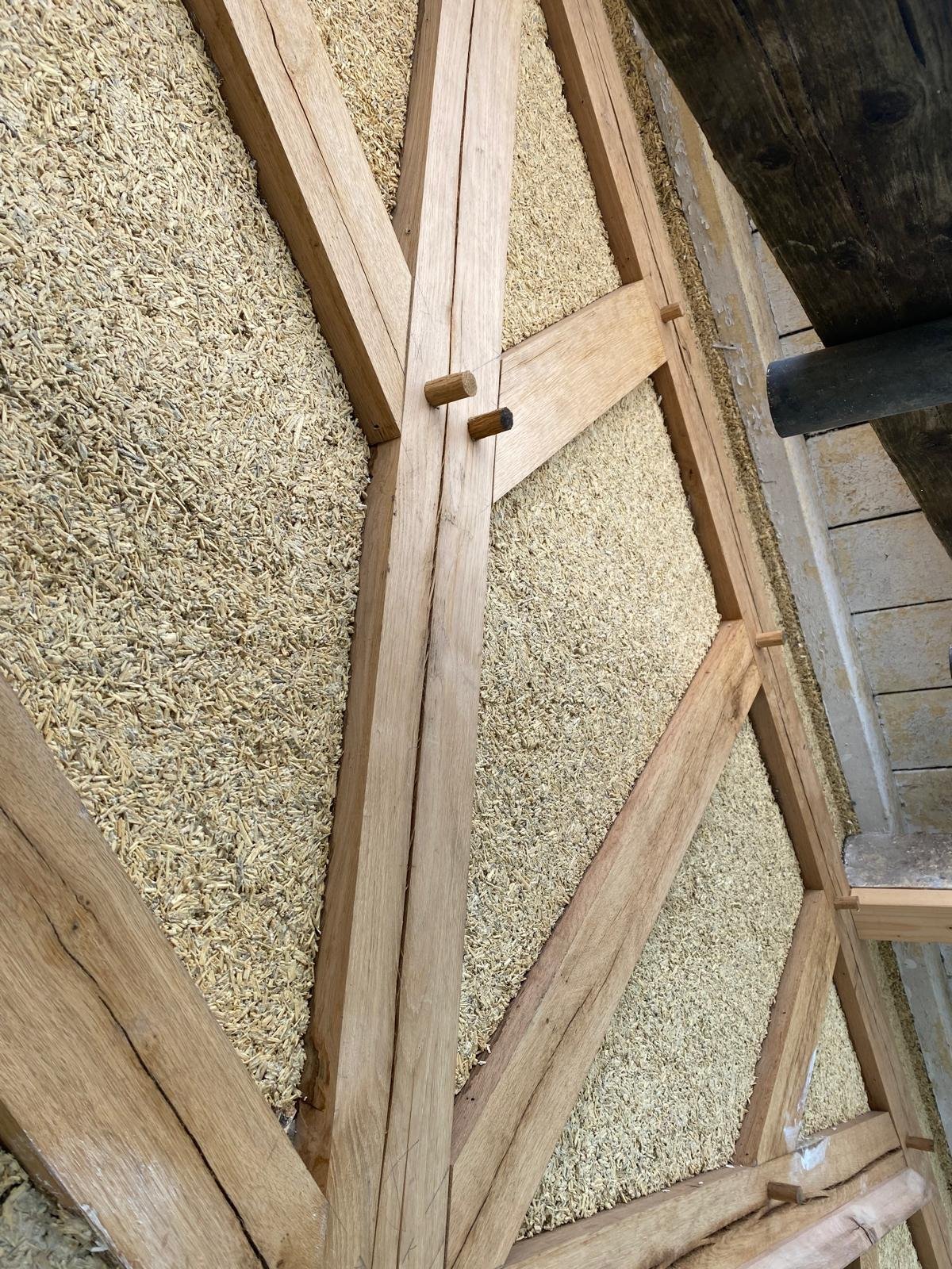 Close-up of a woodworking project with wooden frames and gravel or crushed material inside, likely part of a construction or flooring process.