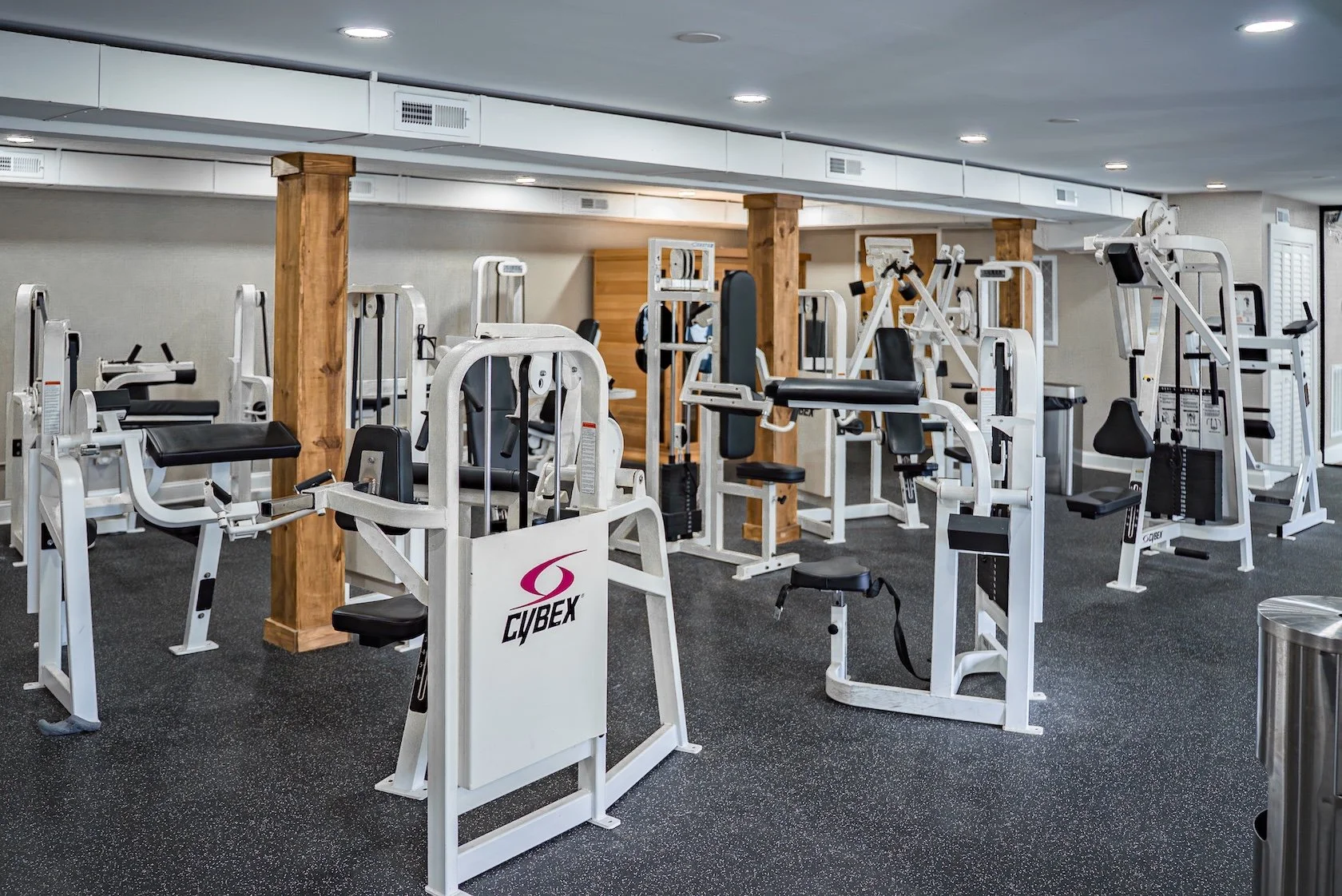 Indoor gym with various strength training and exercise equipment, including machines and benches.