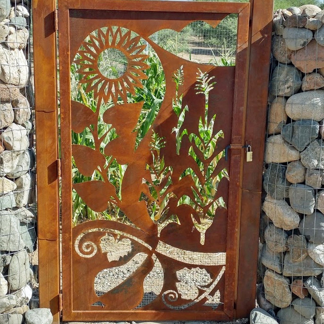 Metal gate with floral cutout design, stone walls, and padlock
