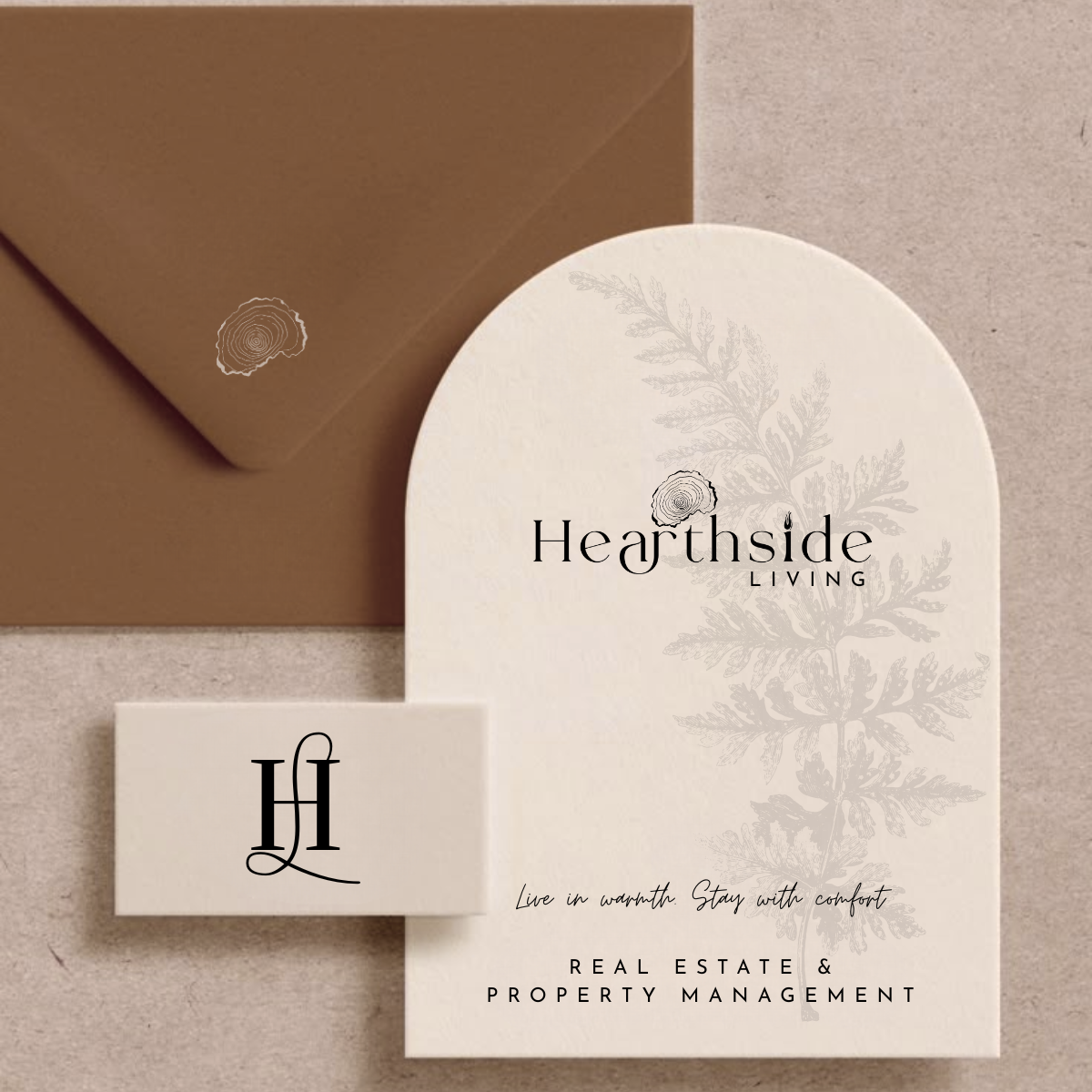 Business card and envelope for Hearthside Living real estate and property management, featuring a tree illustration and elegant typography.