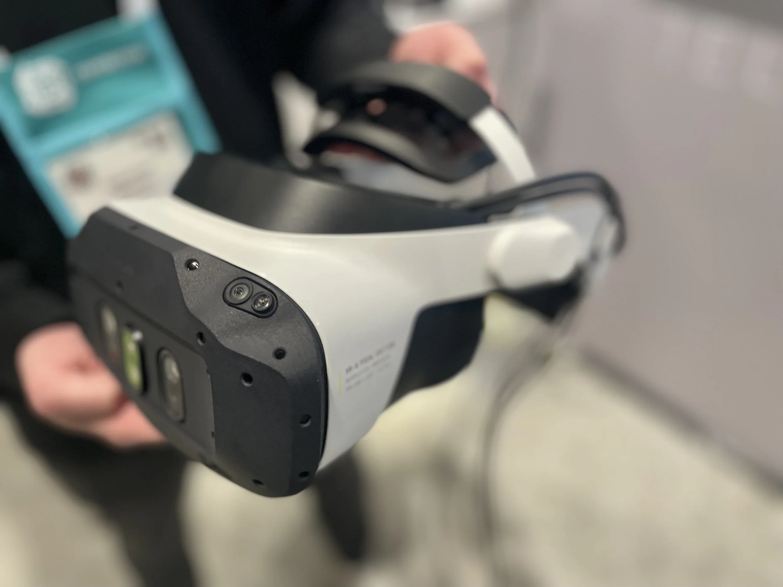 Close-up of a person holding a virtual reality headset with a black and white design.