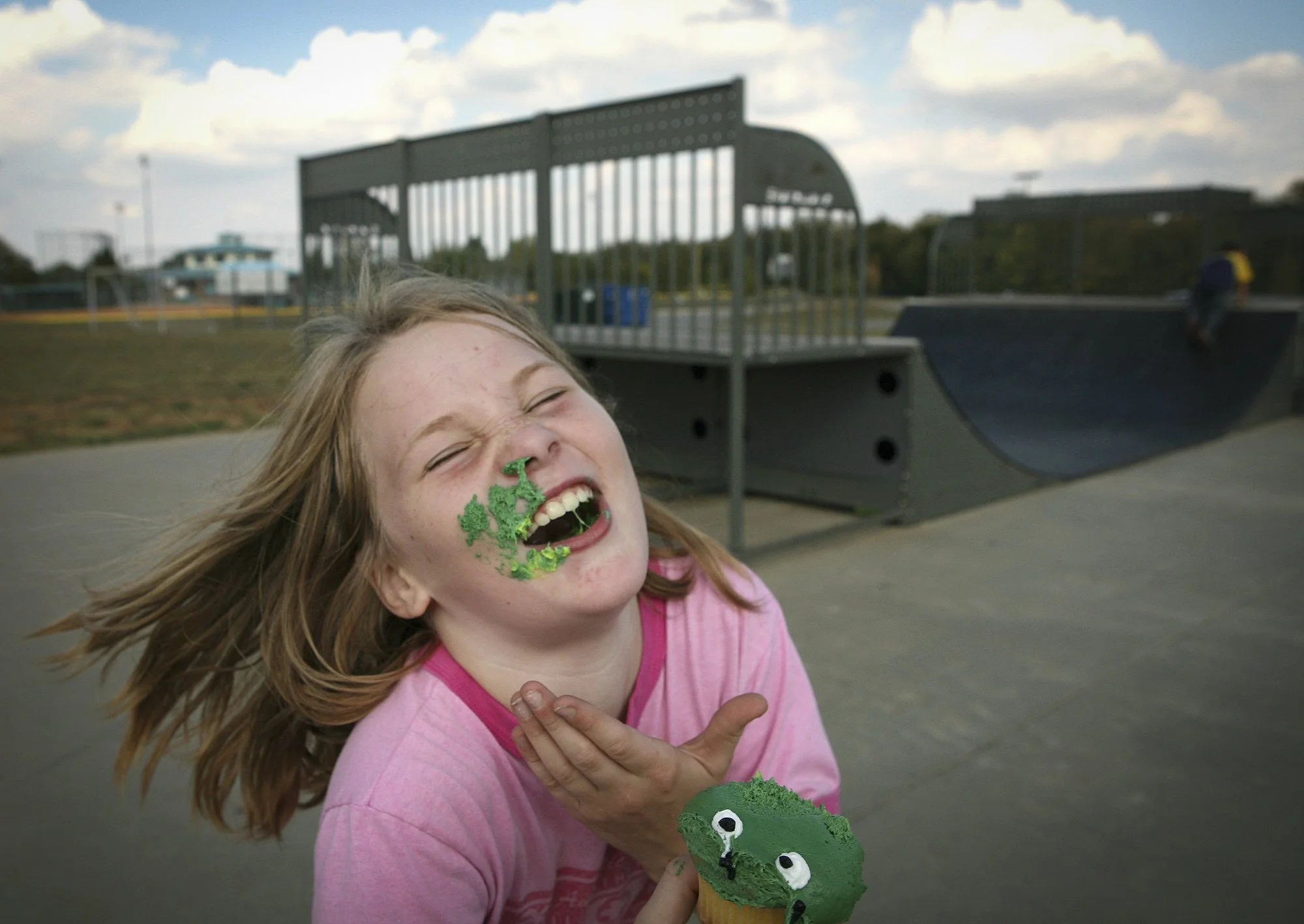 Caitlin Sholar, 9, bursts into laughter after her brother smashes a cupcake into her face at the skate park in Danville, KY. She and her siblings were celebrating a friend’s 9th birthday—fresh off Caitlin’s own big moment, earning MVP on her brothers