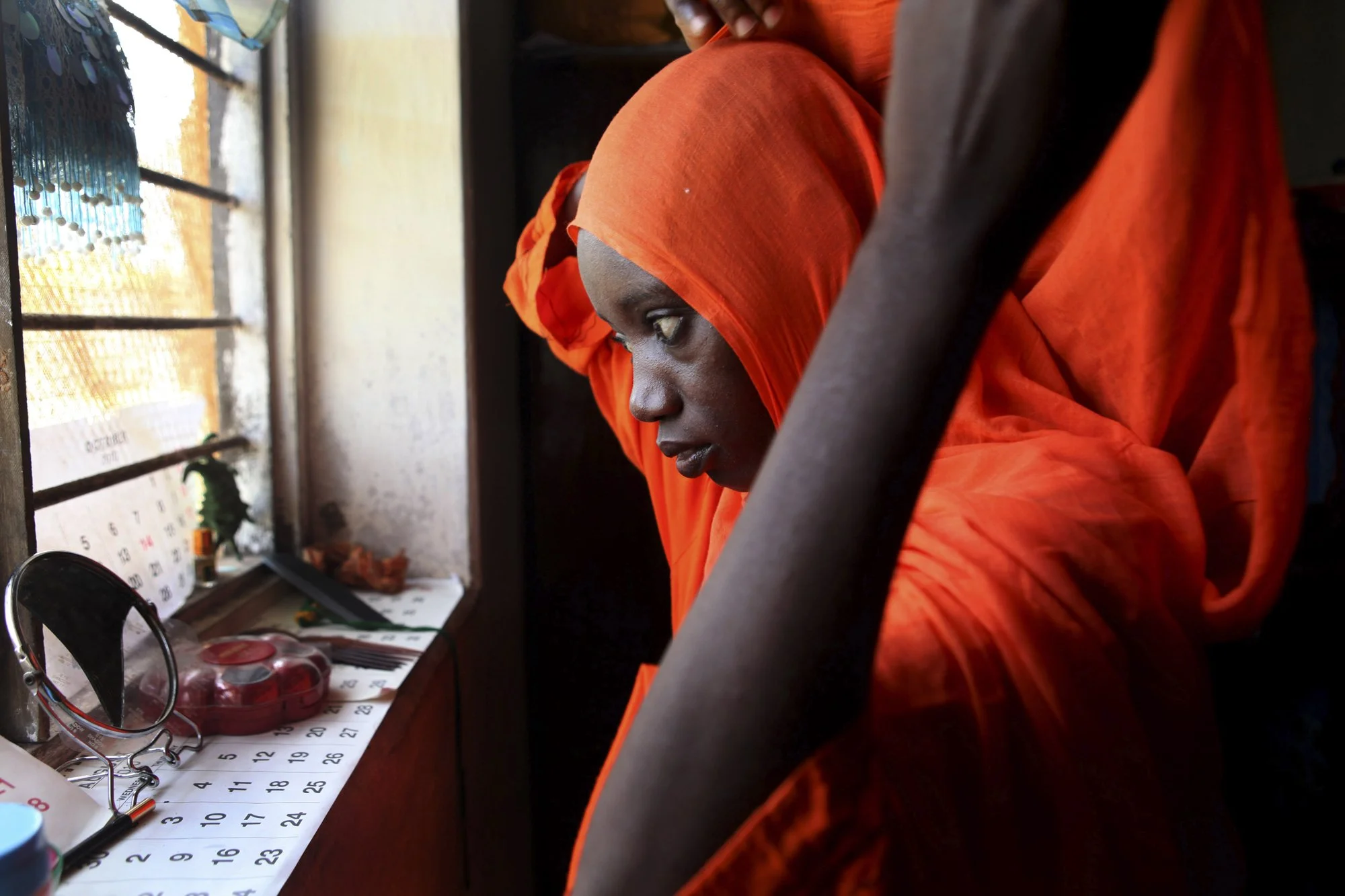 Ikiwa adjusts her hijab at home in Fumba, Zanzibar, after a long day gathering shellfish on the low-tide flats. She is part of a community-based program that trains women to cultivate shellfish—providing a sustainable source of protein for their fami
