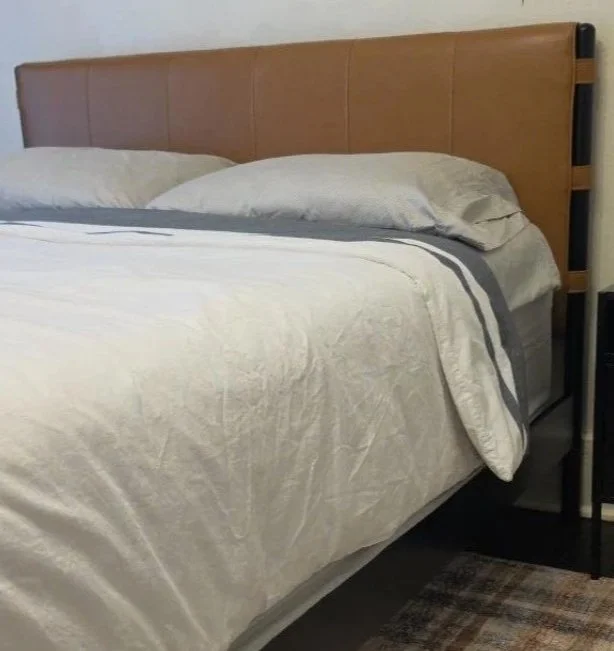 Cognac upholstered queen bed with white bedding in a boy’s bedroom