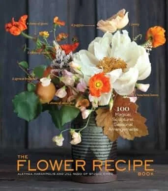 Cover of “The Flower Recipe Book” featuring a colorful floral arrangement in a ceramic vase on a dark wood background