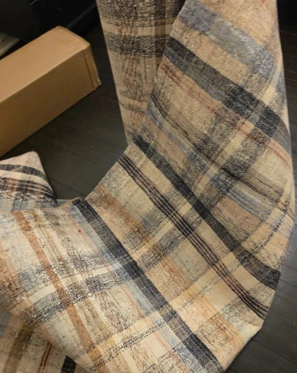 Close-up of the Chris Loves Julia x Loloi plaid rug in tan, blue, black and rust tones