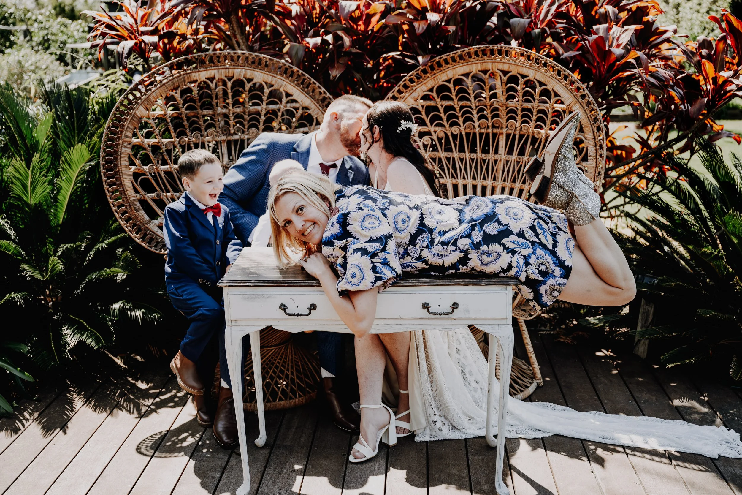 Wedding photographed at Heaven Gardens in Port Stephens by Whimsy & Wonder Photography. A wedding couple kissing in funny moment with celebrant Mel from Marry Me Mel portrait.