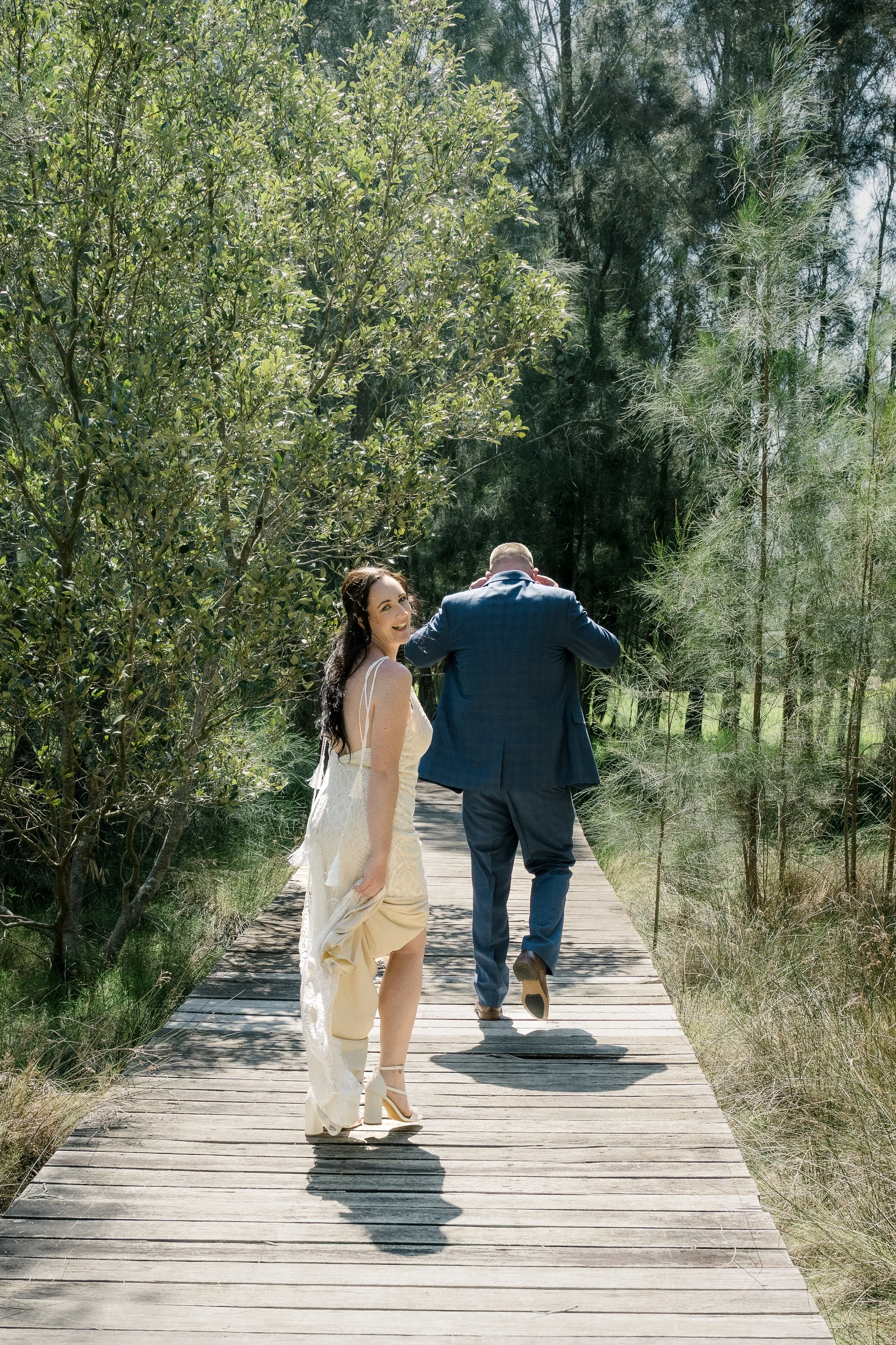 Wedding photographed at Heaven Gardens in Port Stephens by Whimsy & Wonder Photography. A wedding couple kissing in funny moment with celebrant Mel from Marry Me Mel portrait.