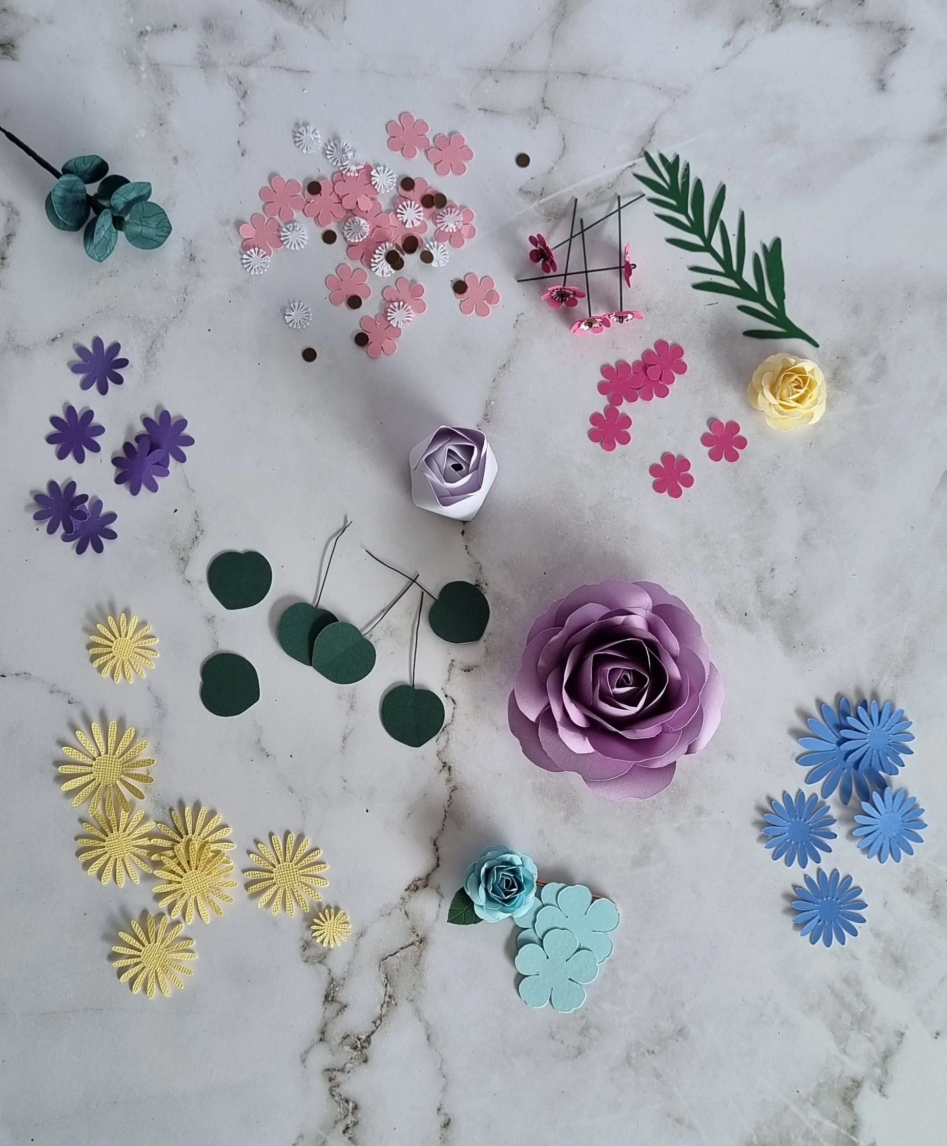 Handmade paper petals and leaves in the process of being made into paper flowers