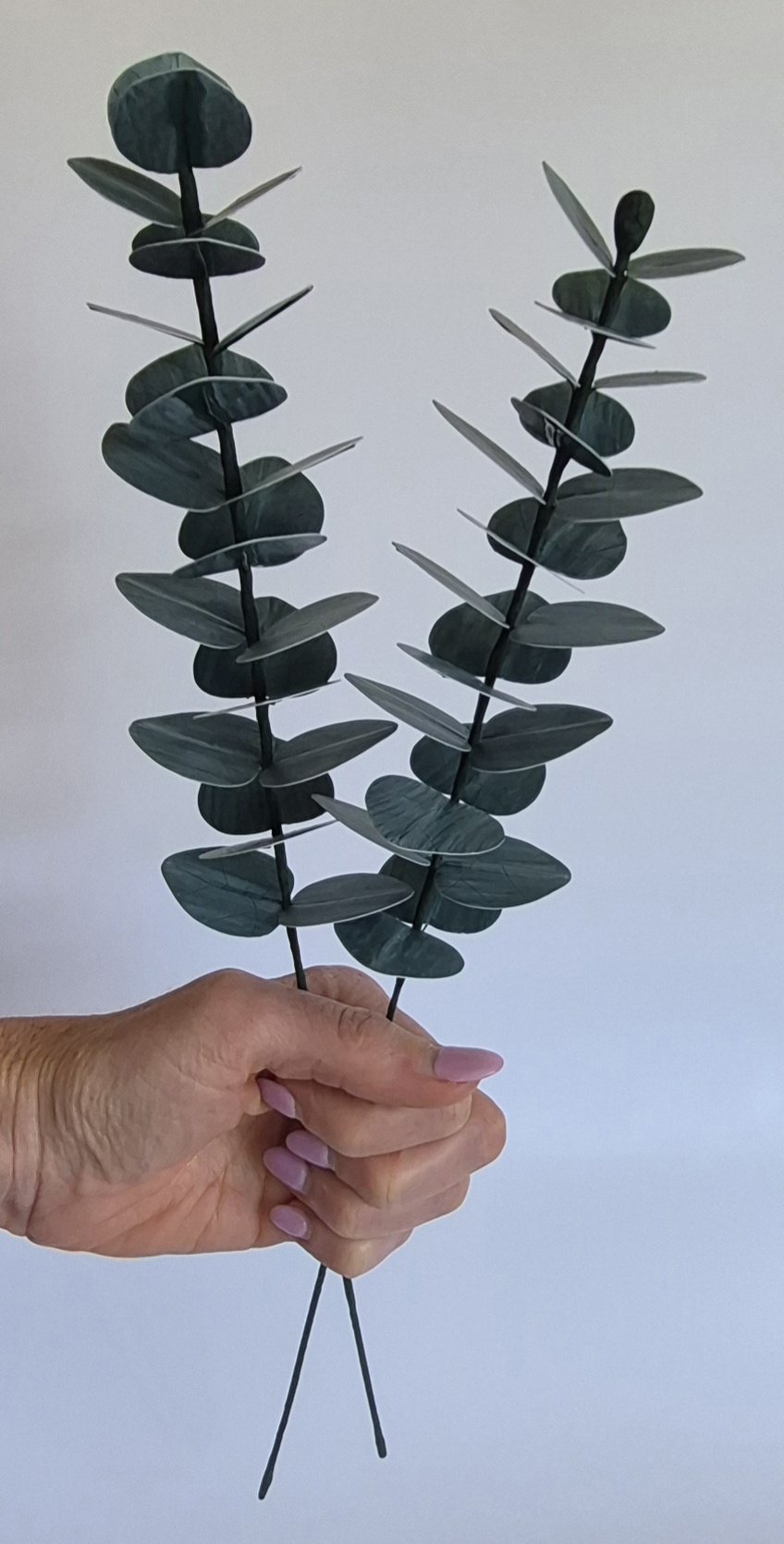 Close-up of handmade paper eucalyptus leaves showing realistic texture and detail