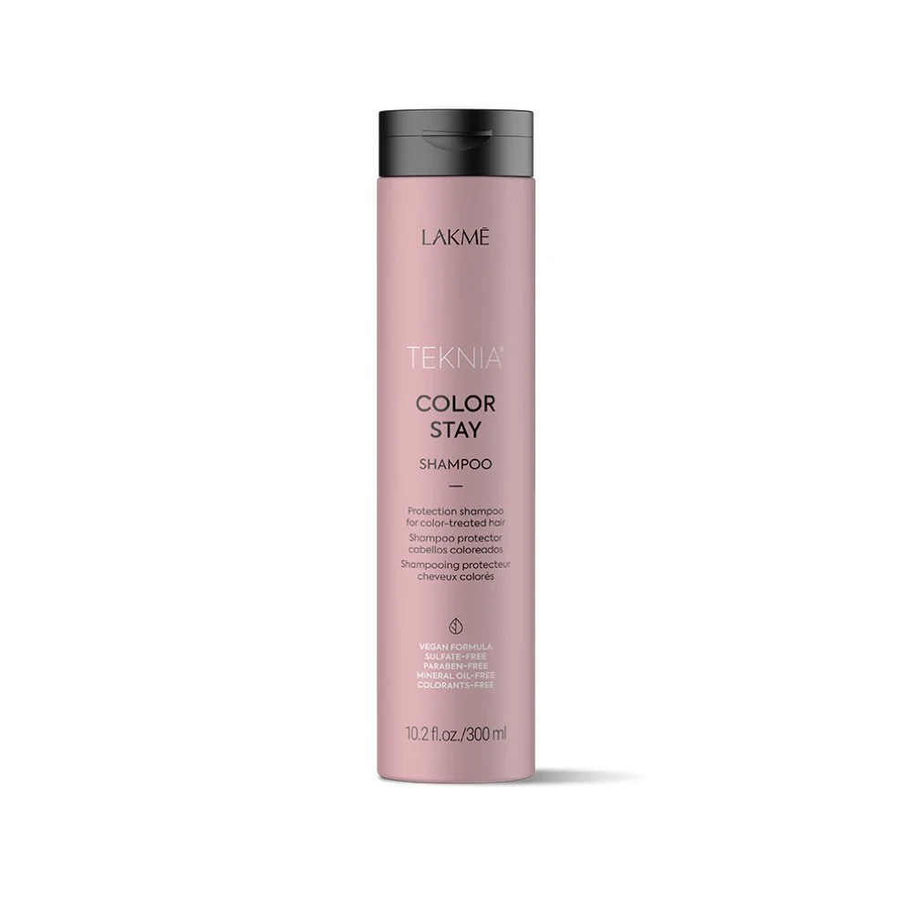 A pink bottle of Lakmé Teknia Color Stay Shampoo with a black cap against a white background.