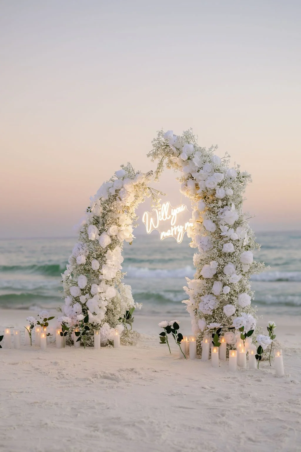 Panama City Beach Proposal with white rose set up and marry me sign from coastal bloom, photos by Panama City beach photographers team 