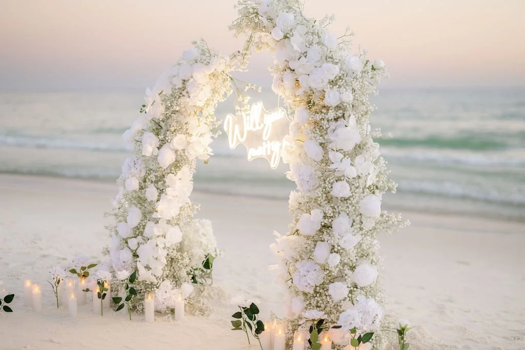 Panama City Beach Proposal with white rose set up and marry me sign from coastal bloom, photos by Panama City beach photographers team 