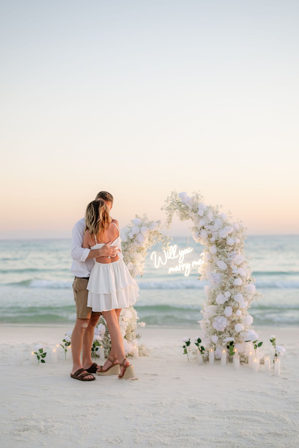 Panama City Beach Proposal with white rose set up and marry me sign from coastal bloom, photos by Panama City beach photographers team 