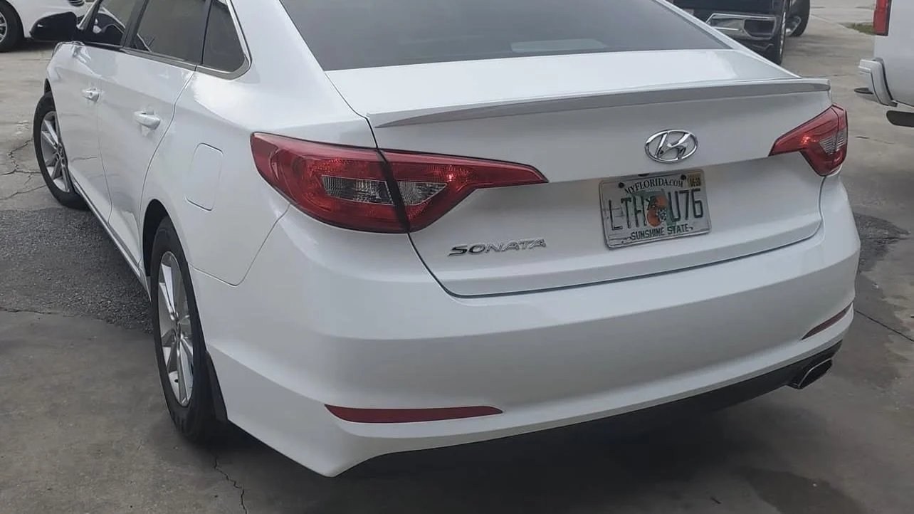 White Hyundai Sonata parked, rear view, Florida license plate.