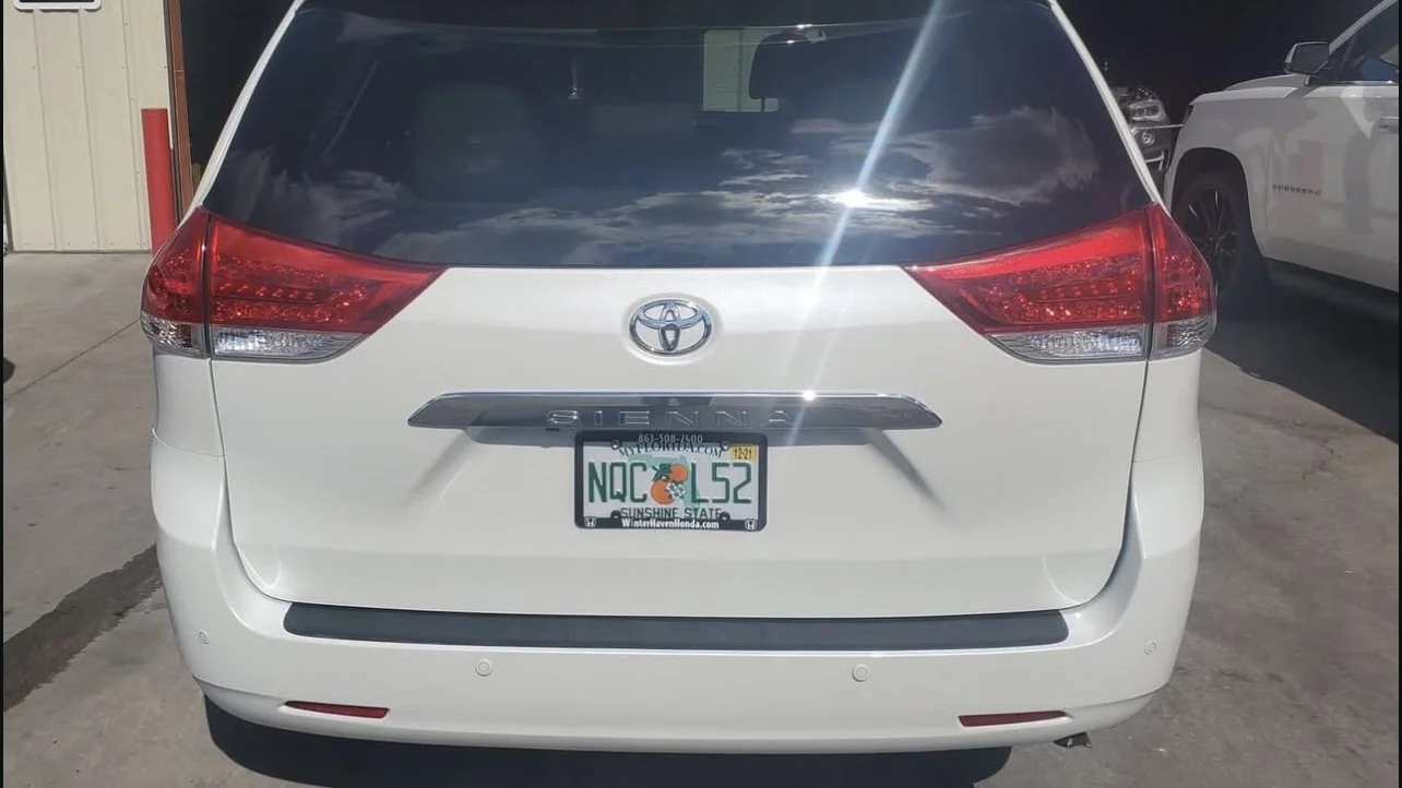 White Toyota Sienna minivan rear view with Florida license plate.