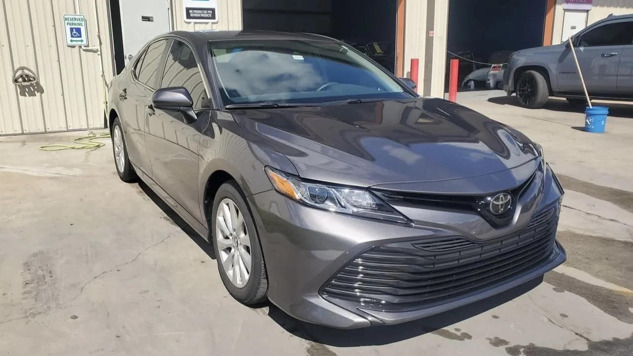 Gray Toyota sedan parked outdoors near a building