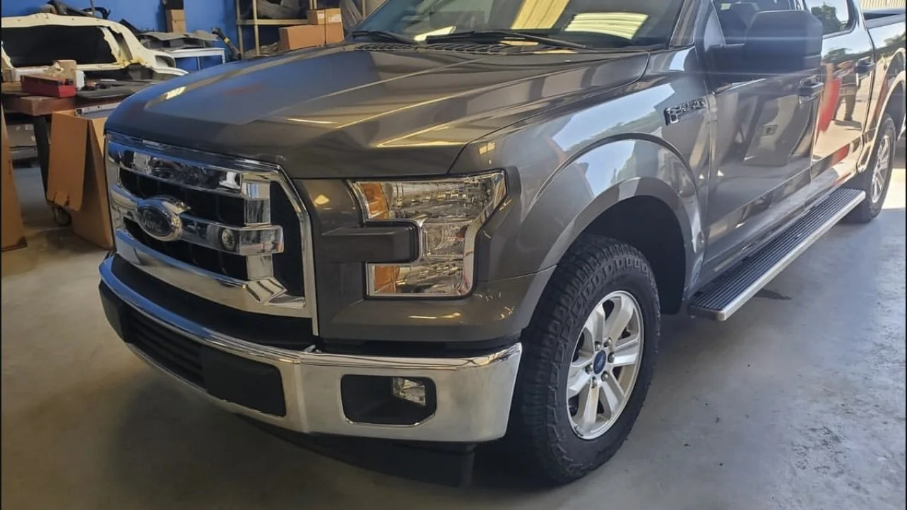 Front view of a gray Ford F-150 truck in a garage.