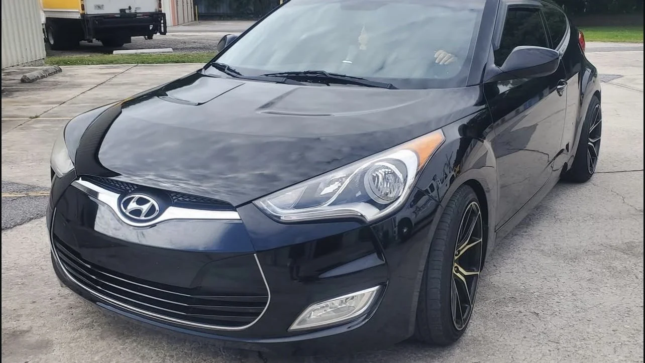 A black Hyundai car parked on concrete.