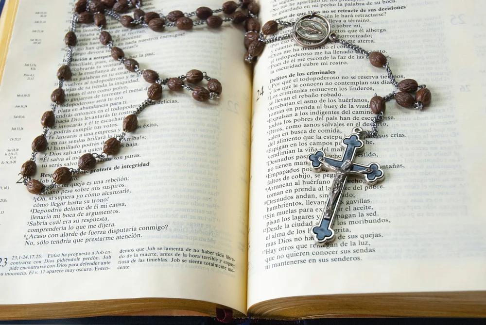 Rosary on open Bible for Catholic discipline article