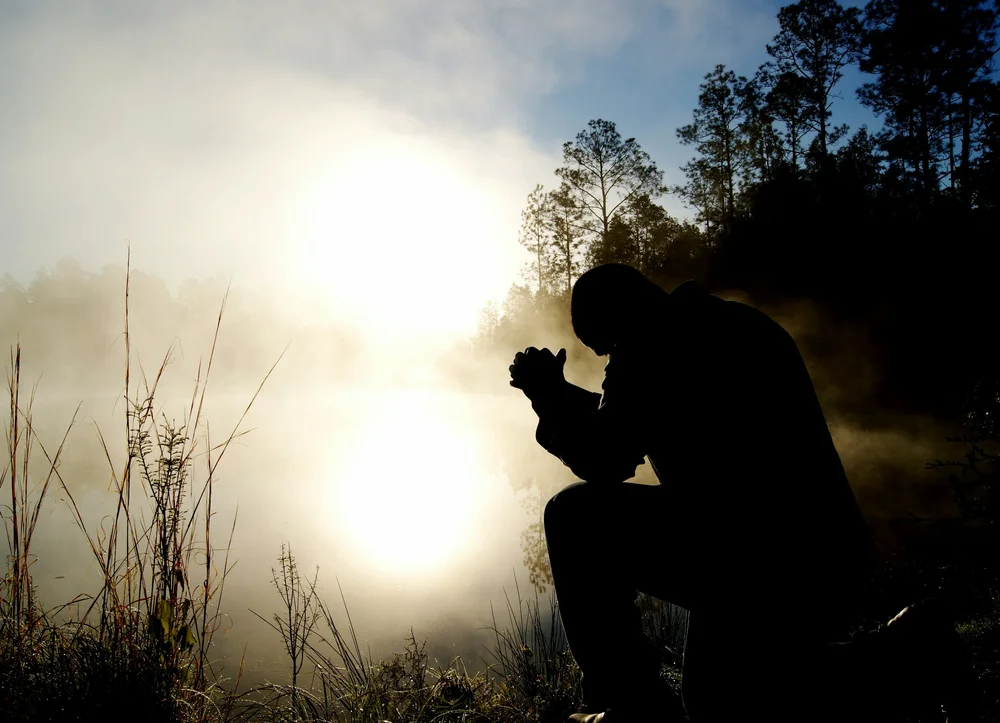 Man praying outdoors for fasting blog article