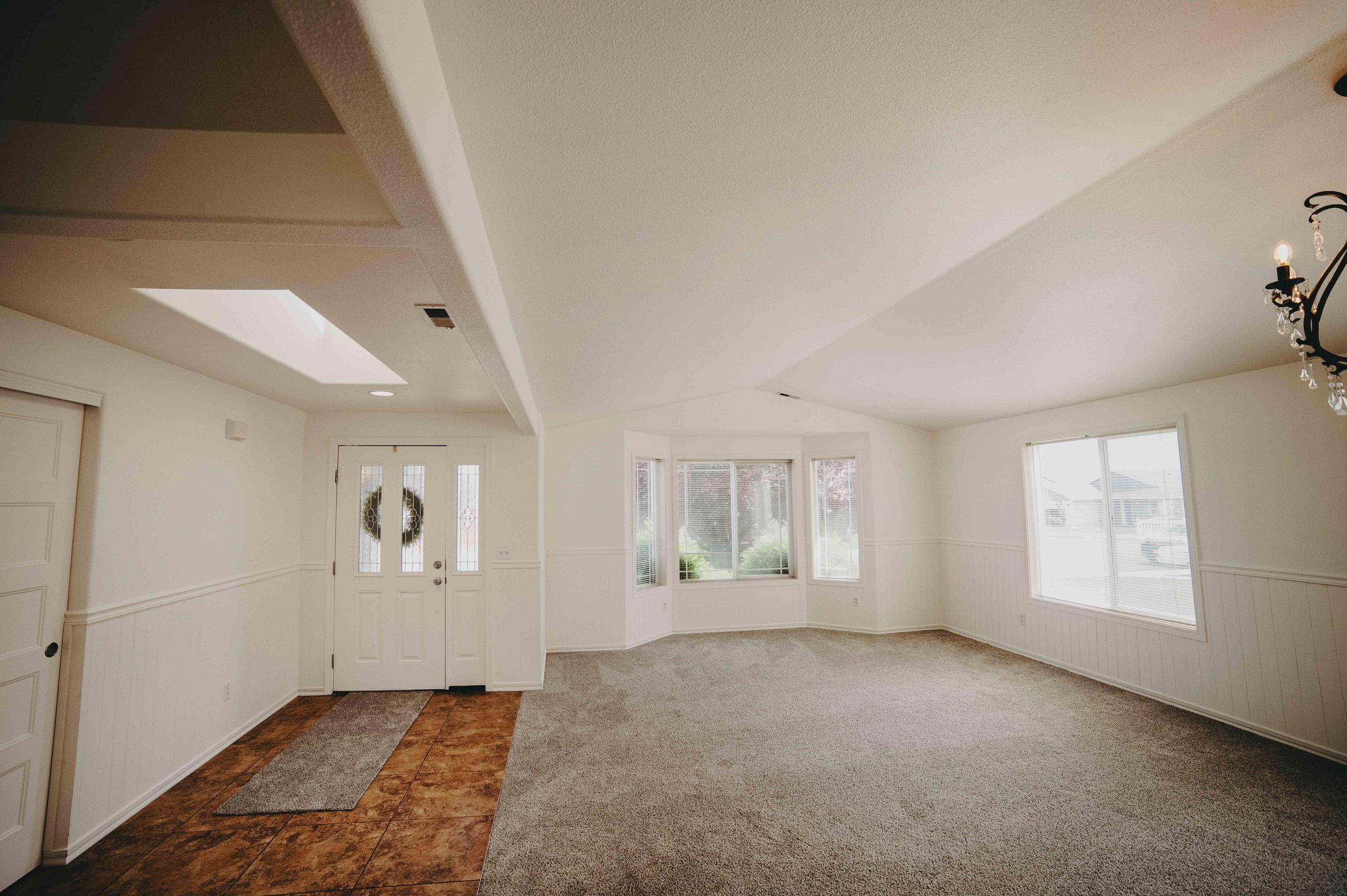 Livingroom at S 13th Sunnyside, WA. The large skylight beautifully lets in ample natural light, vaulted ceilings that add to the feeling of spaciousness and large windows that invite the light in,