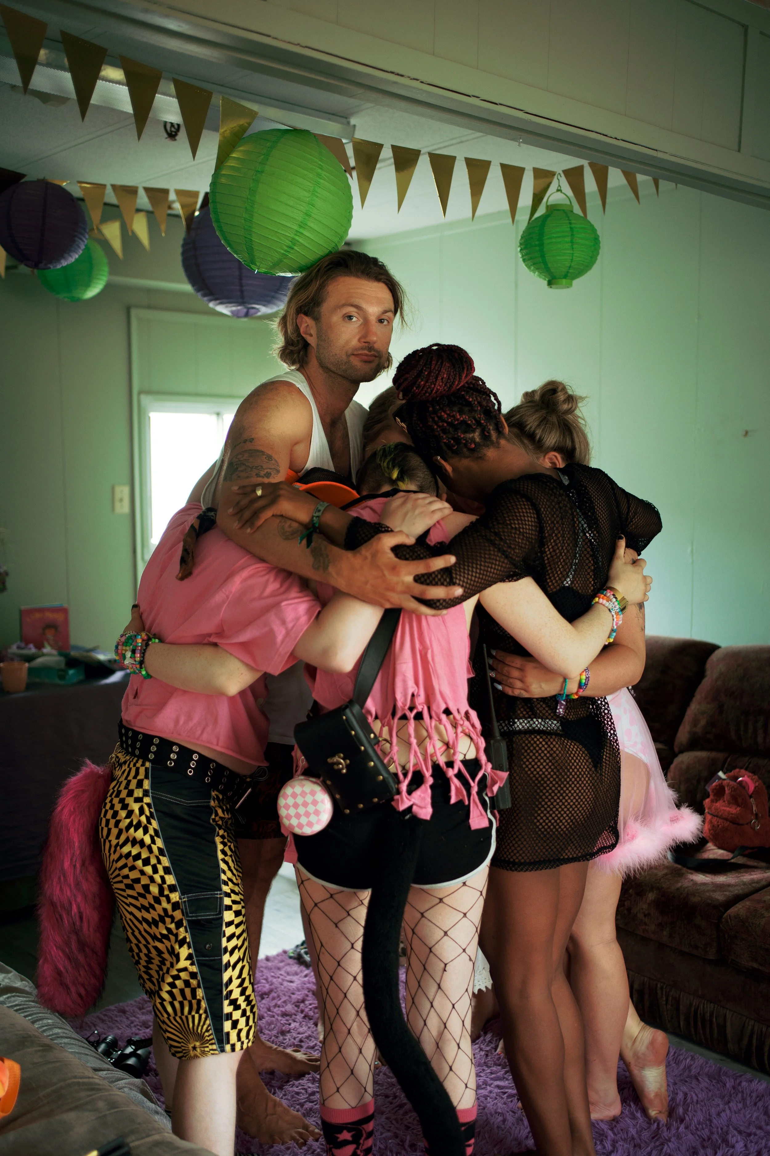 Group of diverse young adults embracing in a cozy living room decorated. Sobriety. 10 Things I Learned Rawdogging a 4-Day Rave Without Booze or Drugs for Vice Magazine and Vice Media, and Bass Coast Music Festival.
